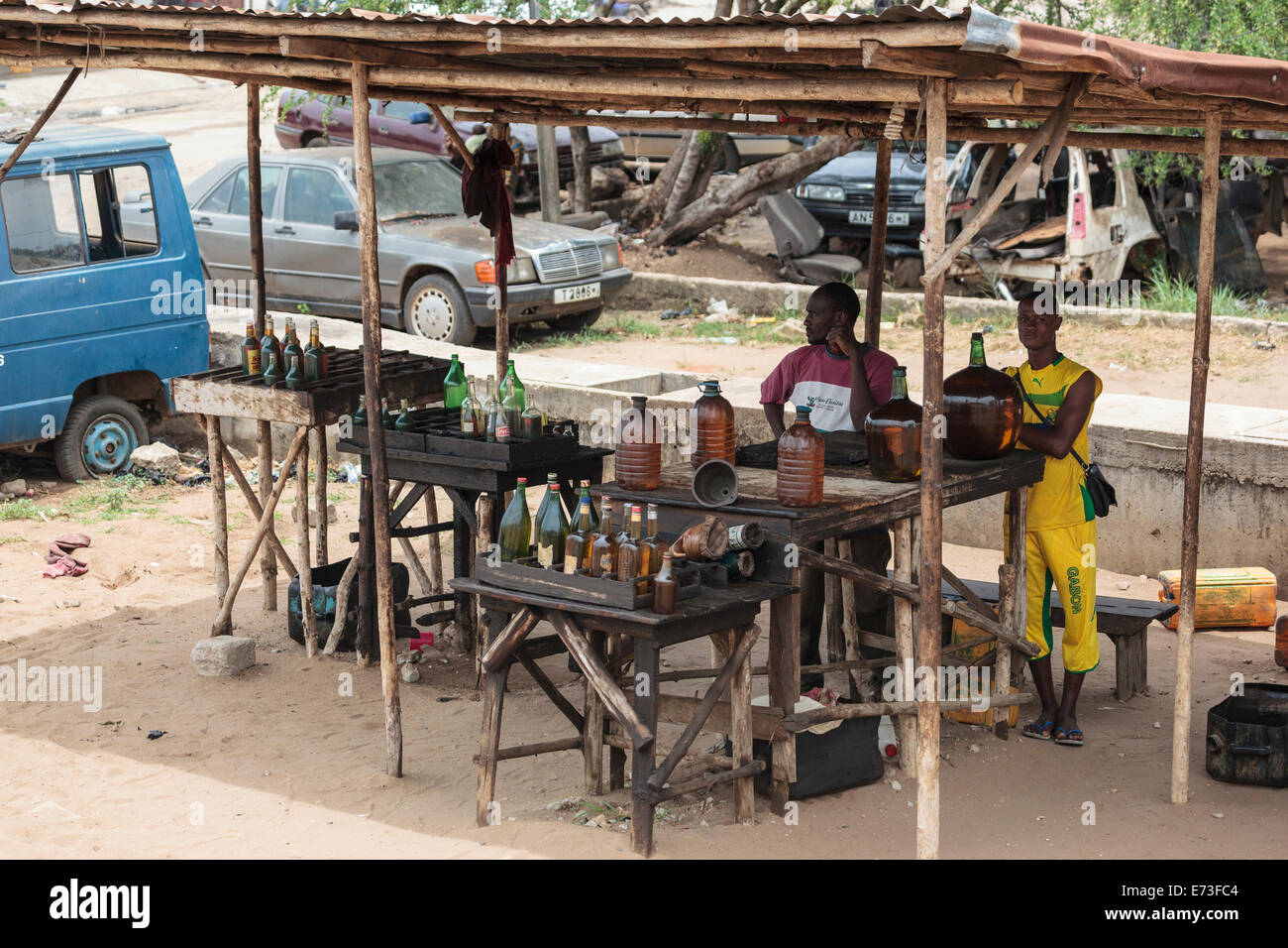 Africa, Benin, Cotonou. Africa, gli uomini la vendita di merce di contrabbando di carburante nigeriano su strada. Foto Stock
