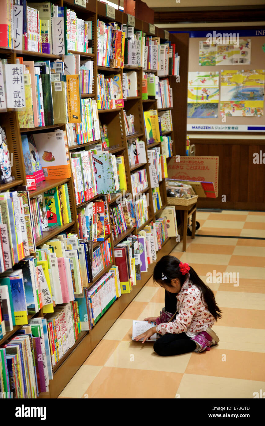 Giovane ragazza giapponese in libreria. Libri per bambini in libreria. Tokyo, Giappone, Asia Foto Stock