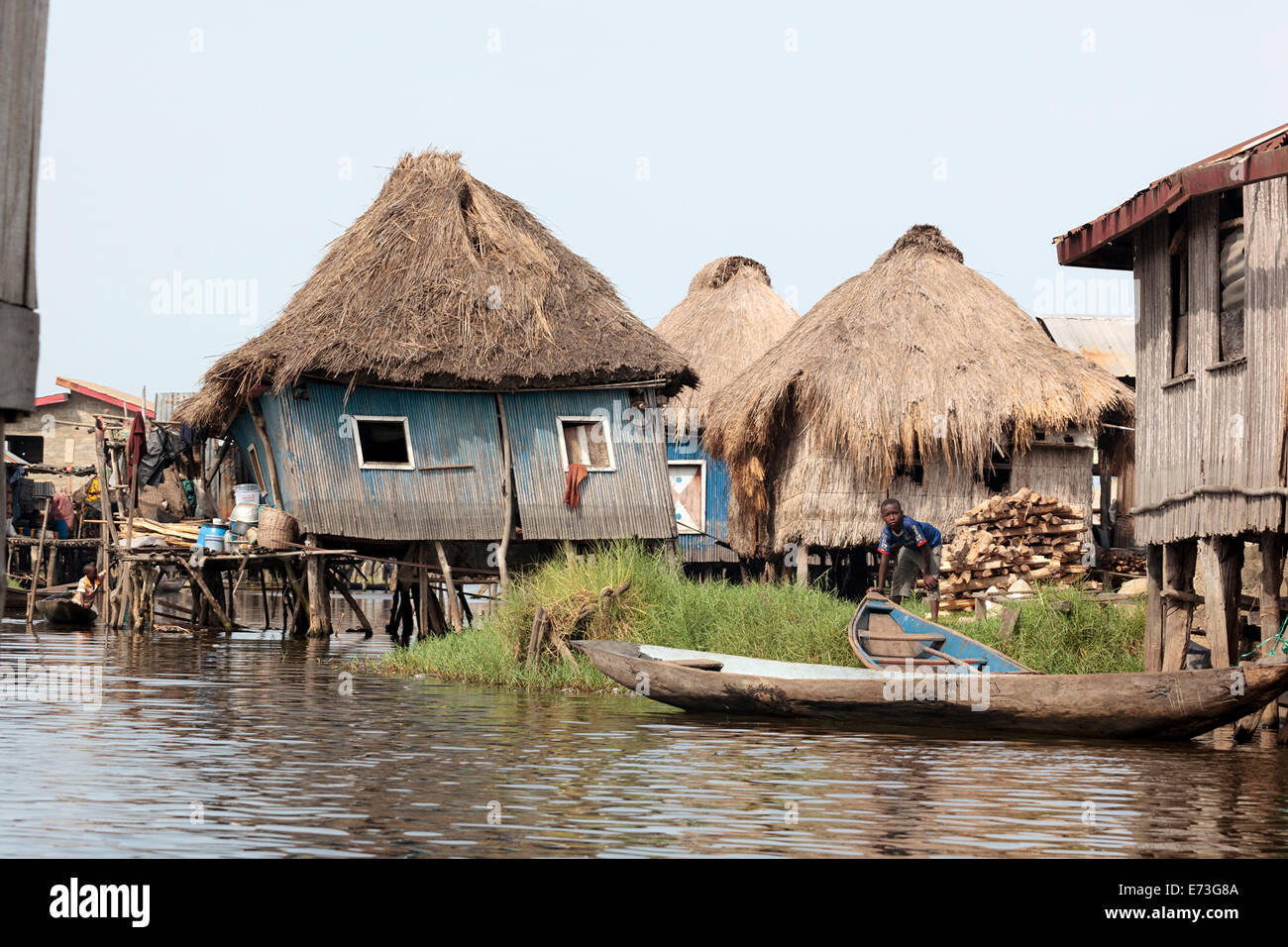 Africa, Benin, Ganvie. Ragazzo con piroga amid stilted strutture sul Lago Nokoue. Foto Stock