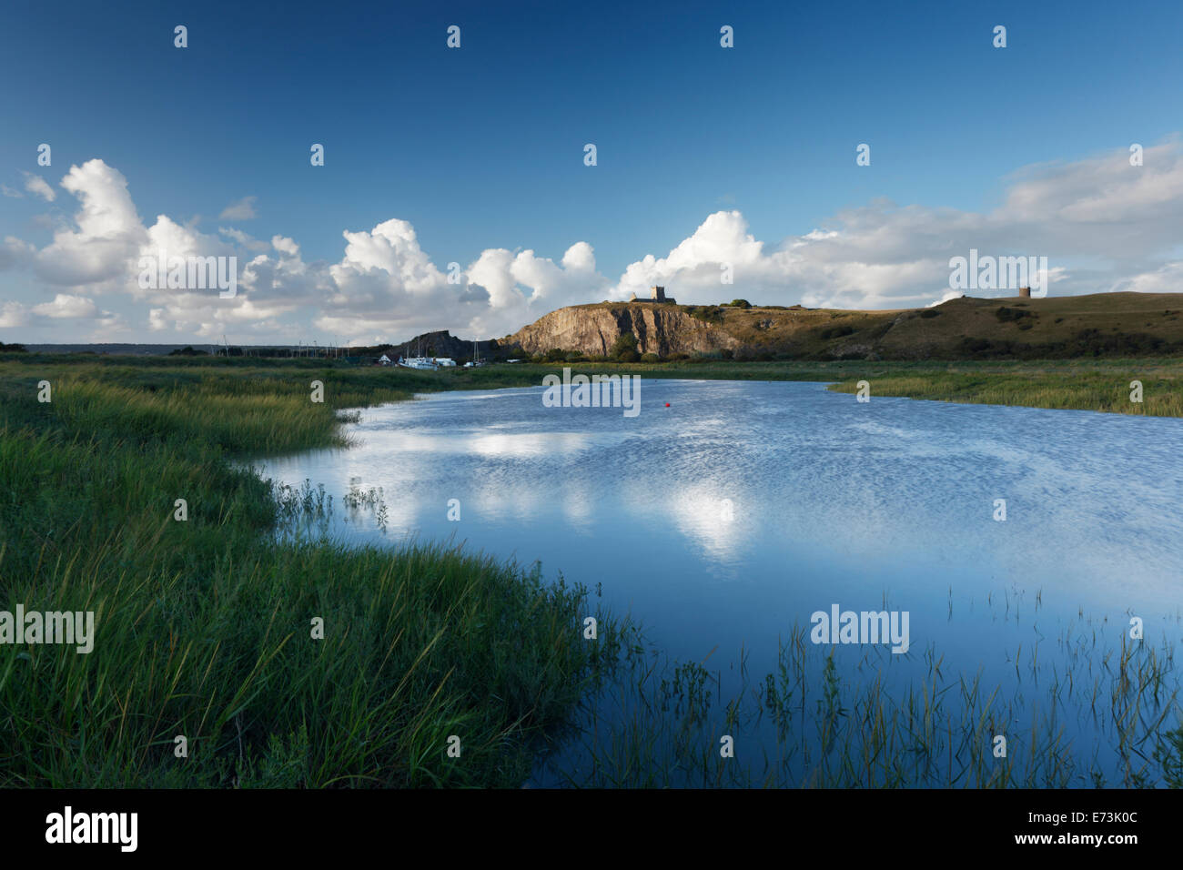 Fiume Ax in salita con la vecchia chiesa di St Nicholas sulla rupe-top. Somerset. In Inghilterra. Regno Unito. Foto Stock