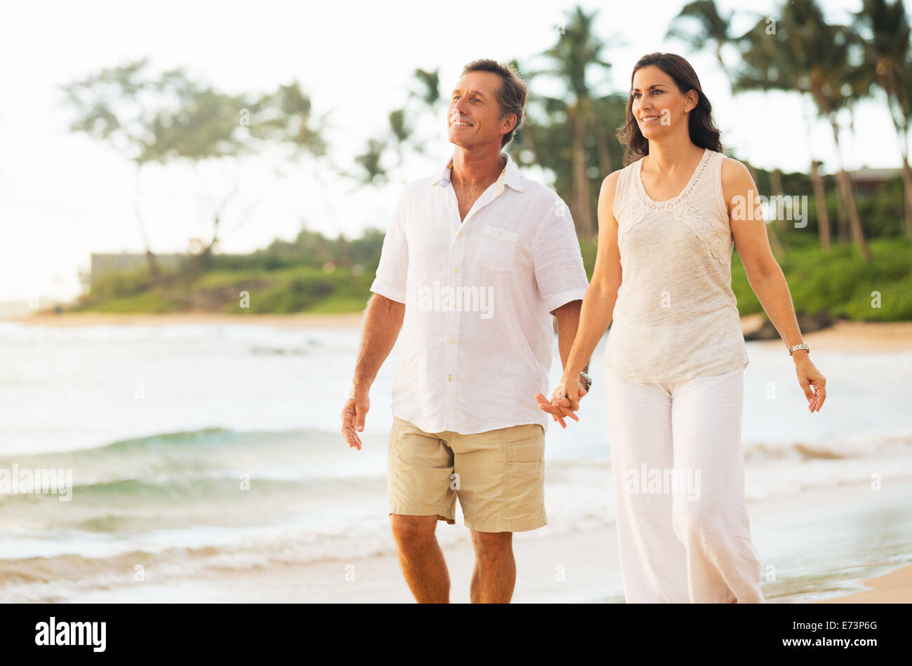 Romantico Coppia Matura godendo di camminare sulla spiaggia Foto Stock