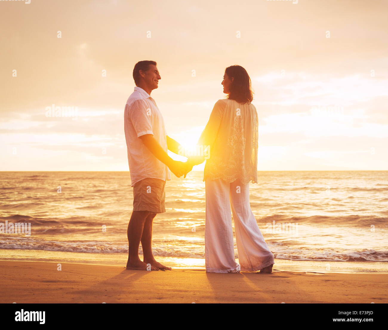 Romantico Coppia Matura godersi il tramonto sulla spiaggia Foto Stock