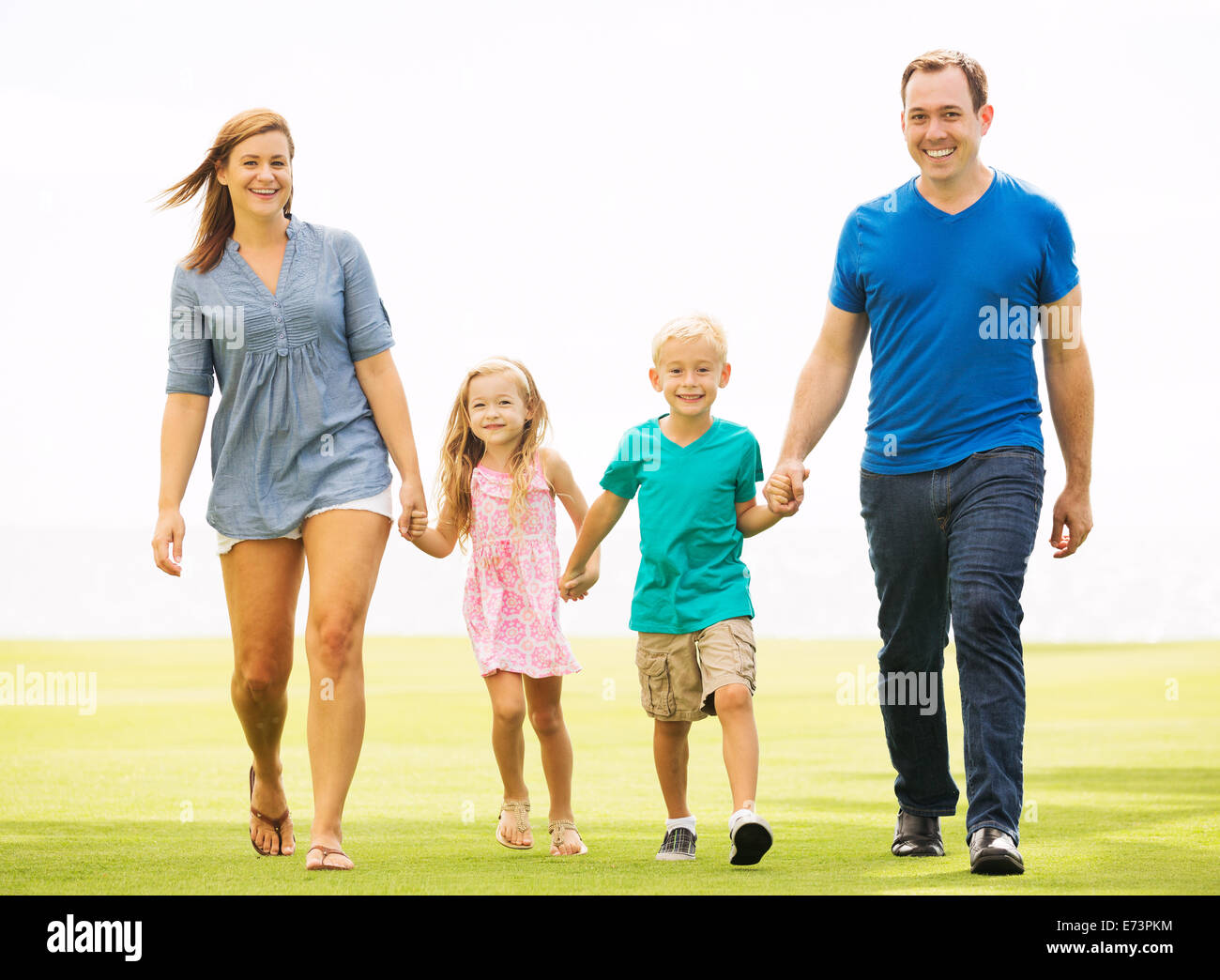 La famiglia felice al di fuori di erba Foto Stock