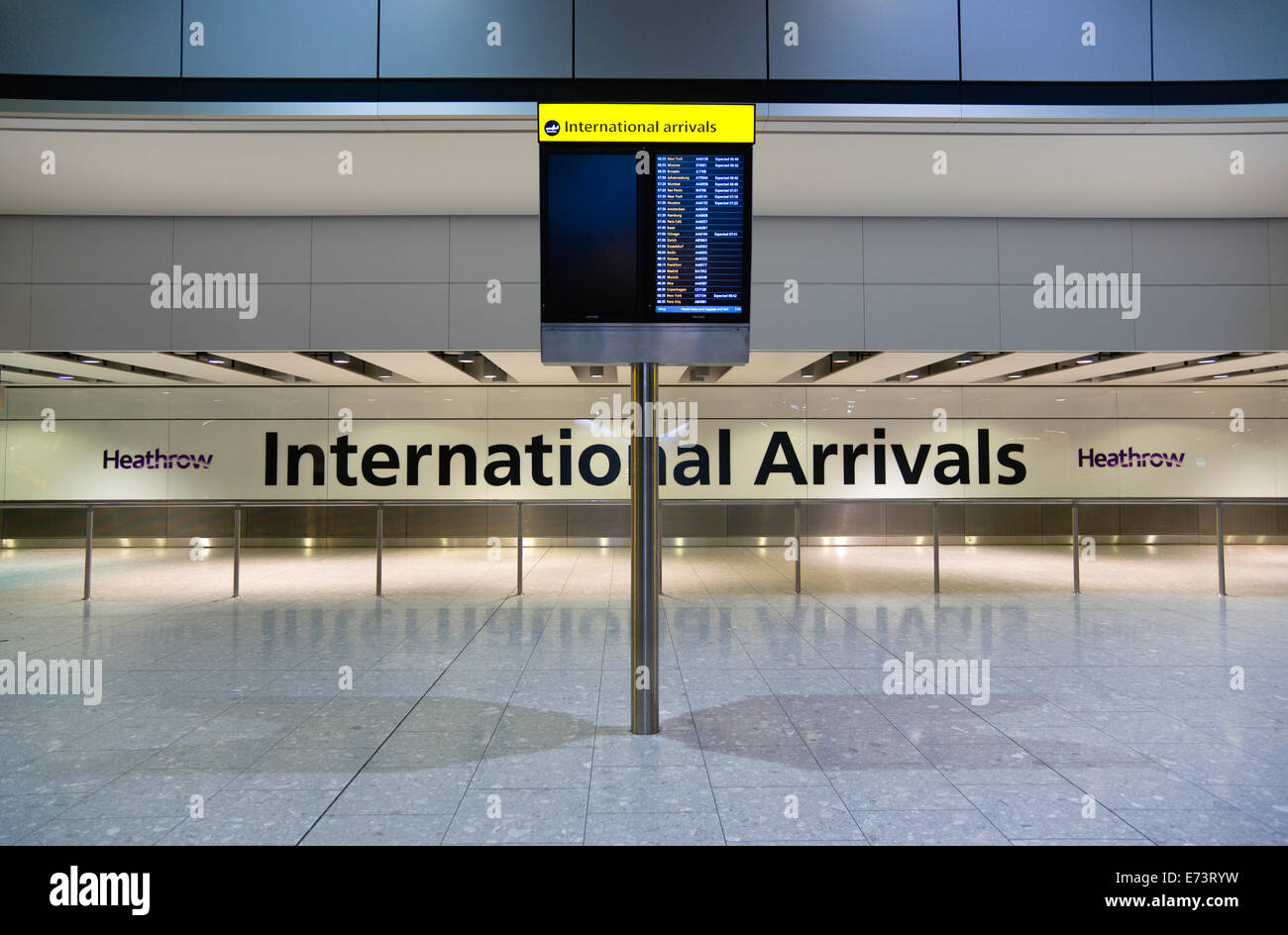 Inghilterra, London, Aereoporto di Heathrow, deserte International hall degli arrivi del Terminal 5 con elettronica di bordo arrivi Foto Stock