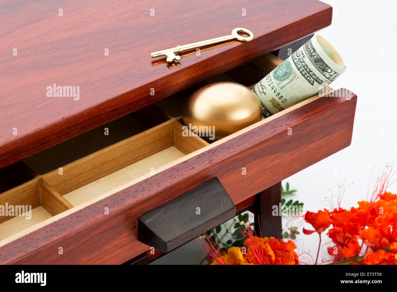 Femminile, immagine finanziaria dei risparmi rappresentati con il legno della scatola granella, aprire il cassetto, oro uovo di nido, chiave e moneta americana. Foto Stock