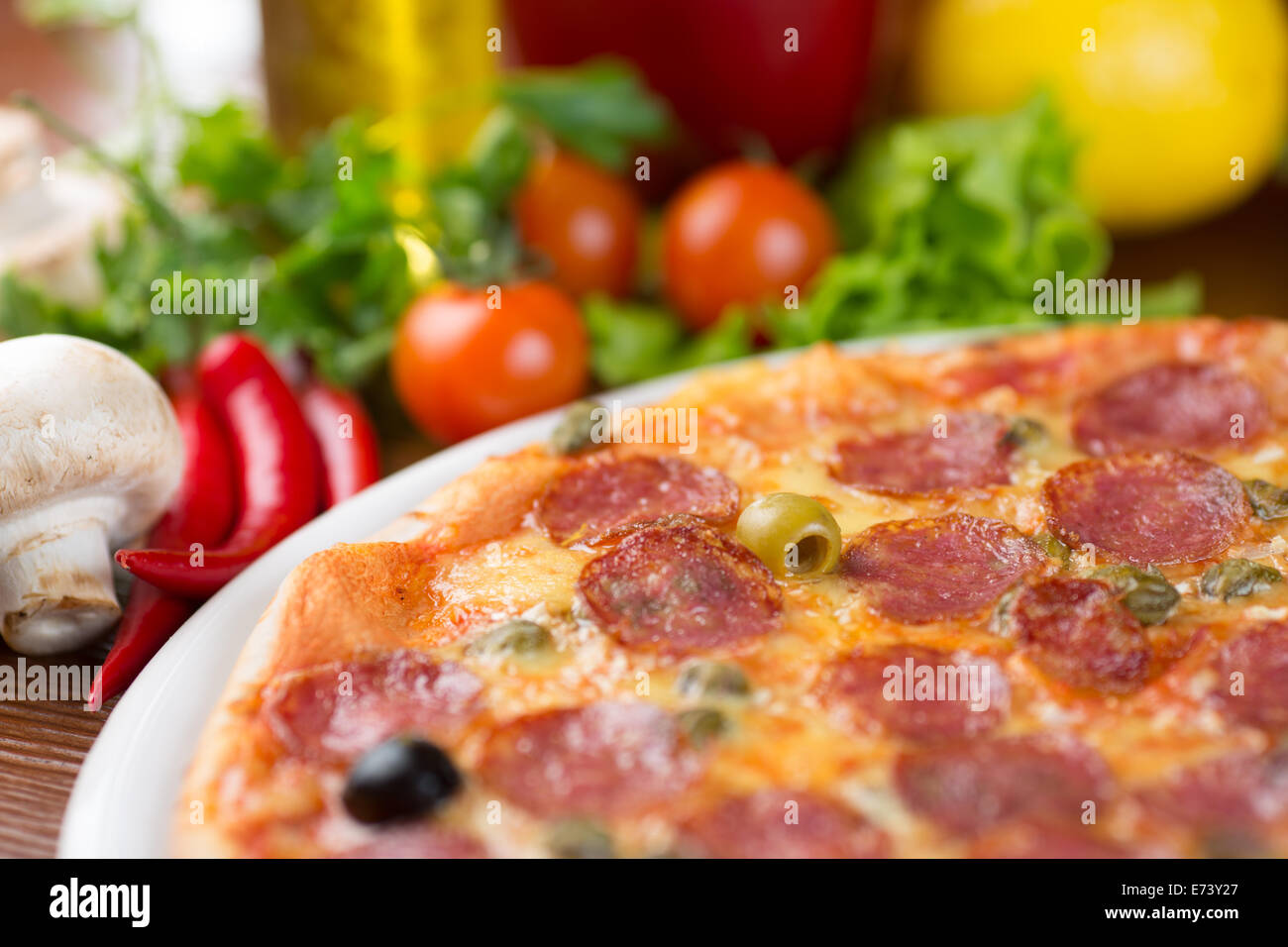 Salame salsicce pizza closeup sulla tavola con verdure Foto Stock