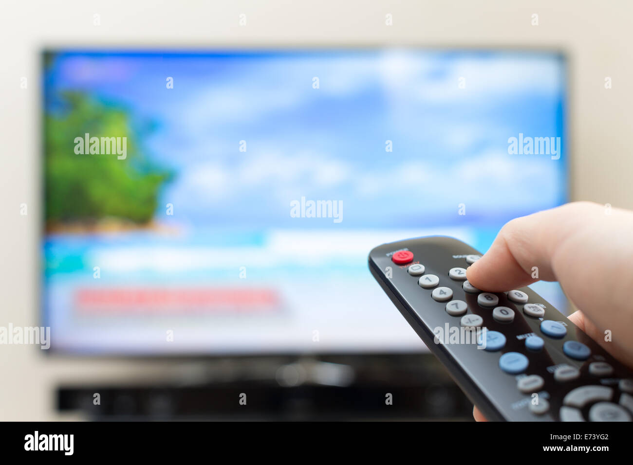 Programma di commutazione o premendo il pulsante sul telecomando del televisore Foto Stock