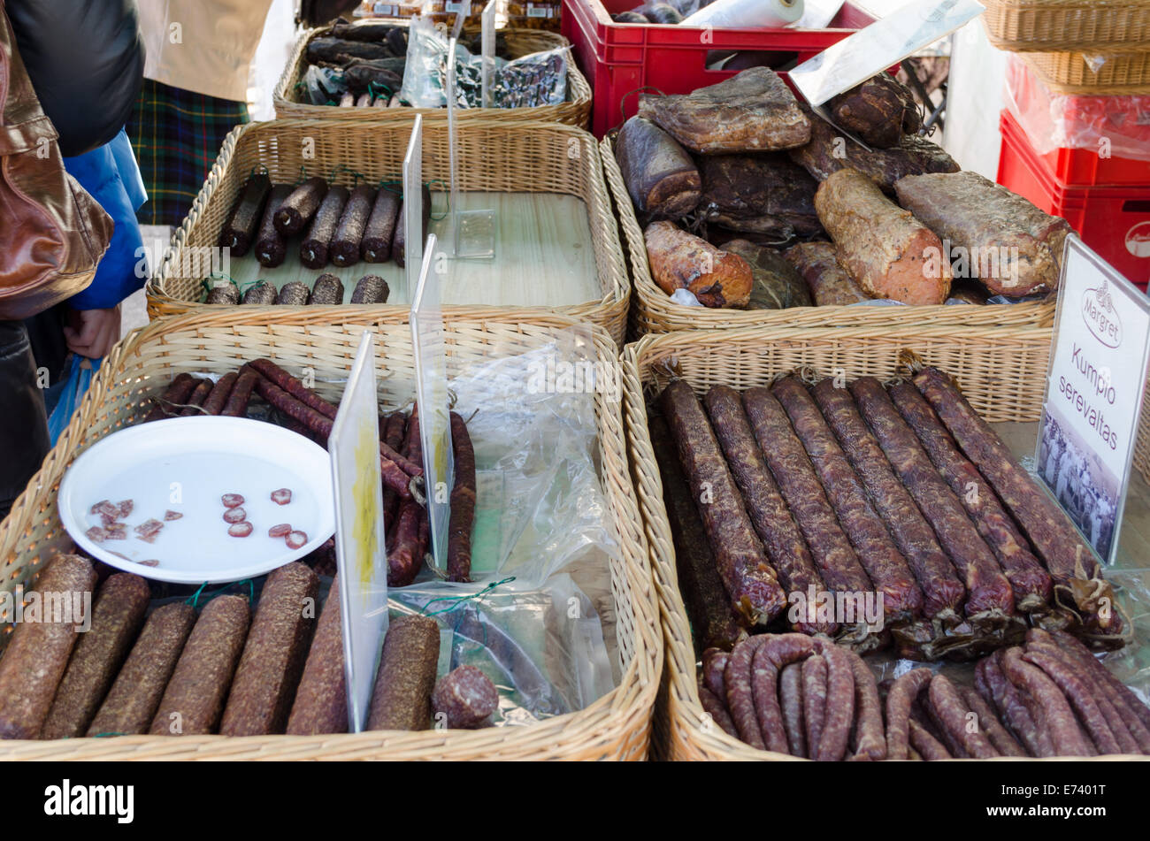 Salsiccia affumicata prodotti posti in cesti di vimini in vendita e degustazione presso il mercato Foto Stock