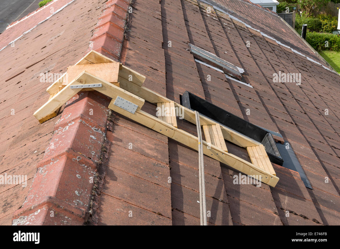 La casa con tetto scaletta da un lucernario finestra, con fune di sicurezza. Droylsden, Tameside, Manchester, Inghilterra, Regno Unito Foto Stock