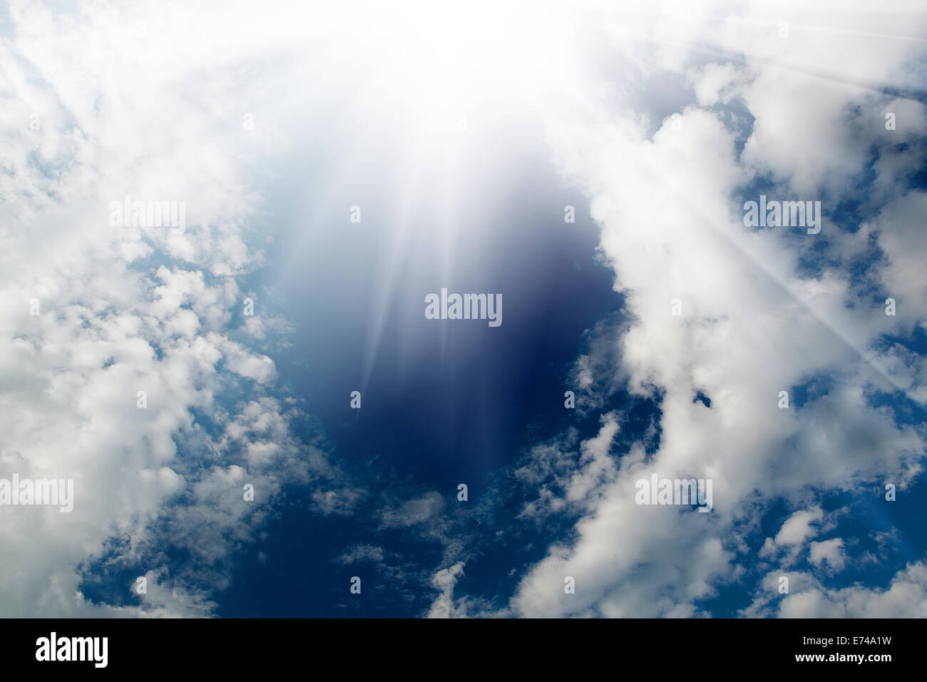 Il bagliore del sole nel cielo con nuvole bianche Foto Stock