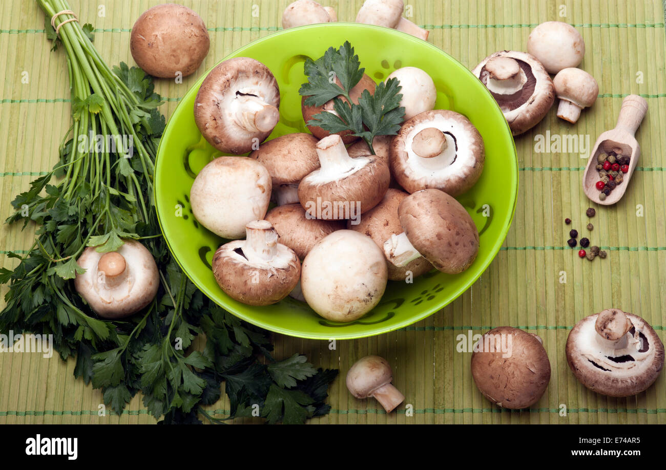 Pulsante o Champignon e Portabello funghi in vaso verde con prezzemolo e pepe misto fagioli. Foto Stock