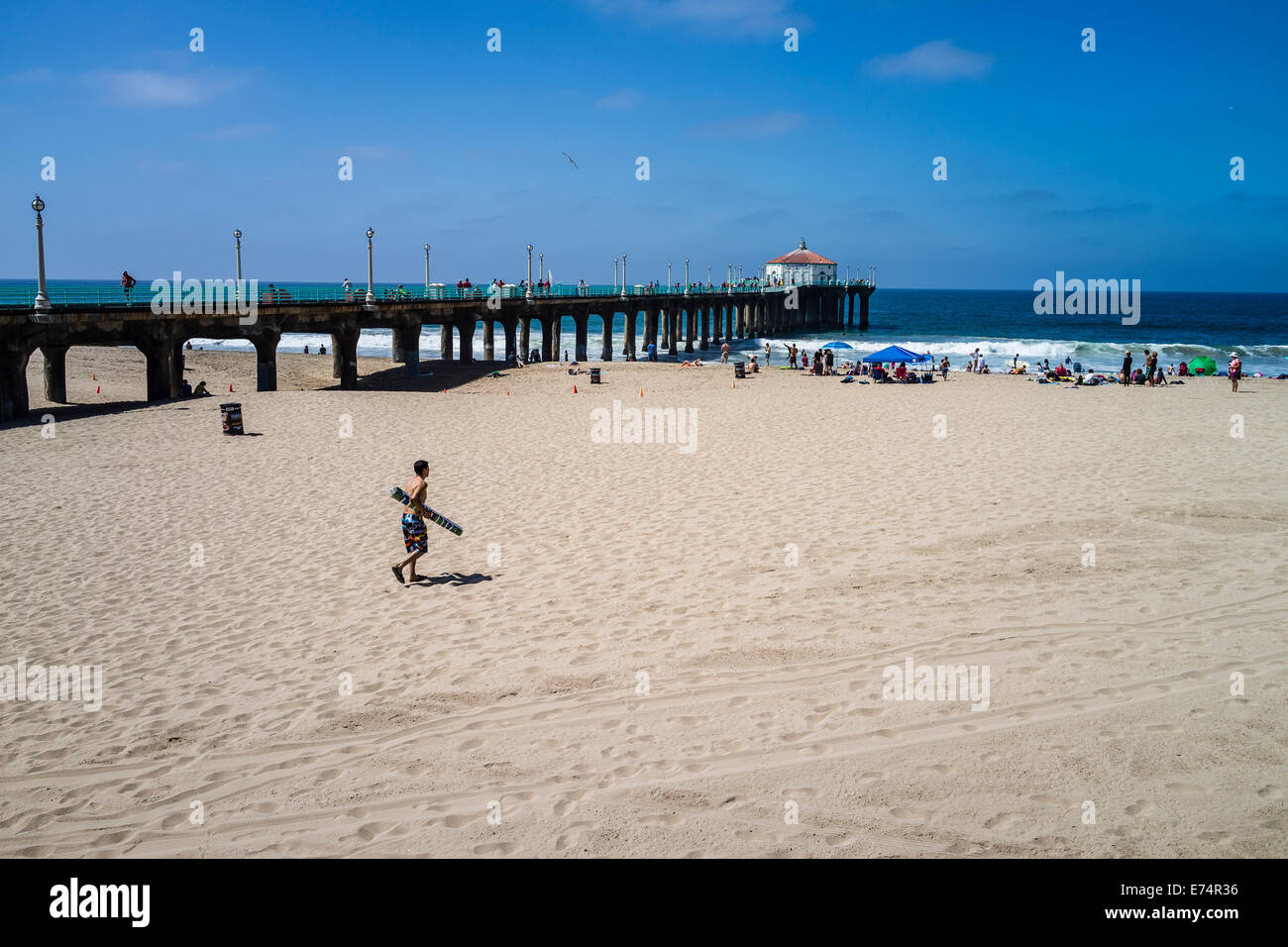 Frequentatori di spiaggia godetevi la sabbia e il surf dal molo municipale a Manhattan Beach in California. Foto Stock