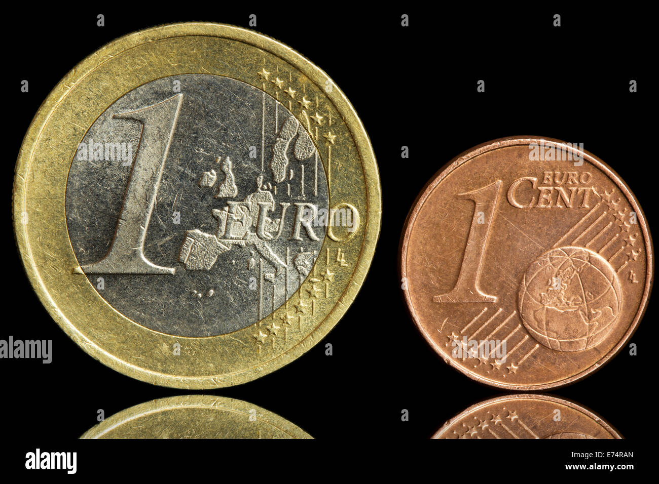 Due impiegati coin - un euro e centesimi di euro - isolato su sfondo nero. Primo piano. Foto Stock