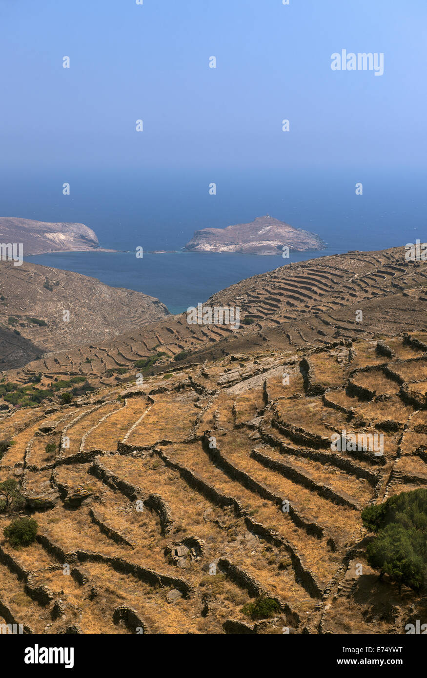 Vista della costa nord dell isola di Tinos e all'isolotto roccioso di "Pianeta" in background, Cicladi Grecia Foto Stock