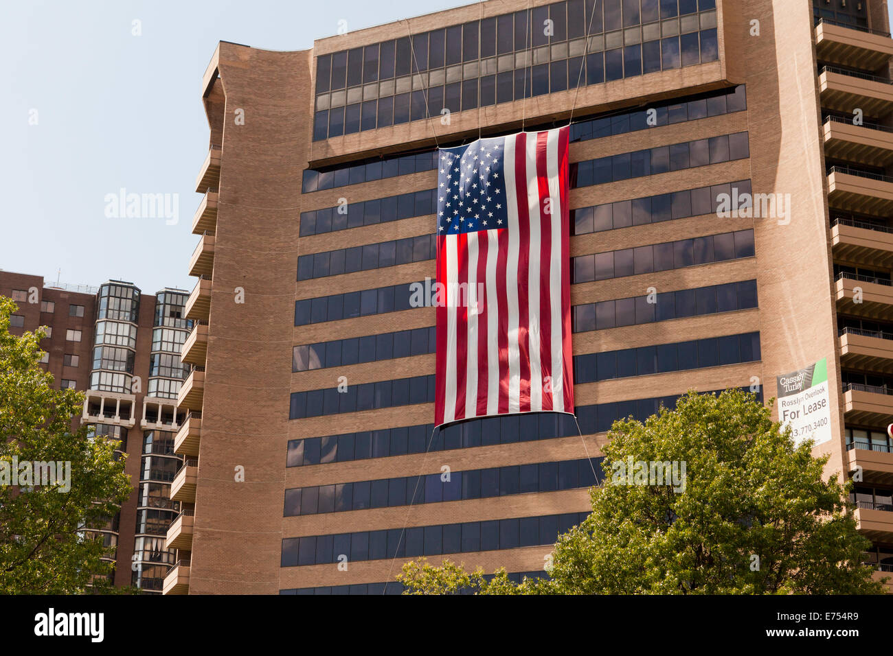 Bandiera americana appesa ad alto edificio di uffici - Arlington, Virginia, Stati Uniti d'America Foto Stock