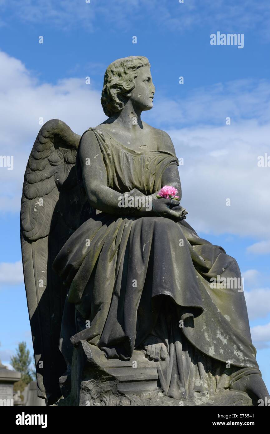 L'angelo tenendo un fiore rosa è un ben noto monumento della necropoli di Glasgow in Scozia. Foto Stock