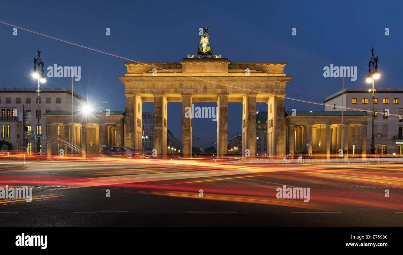 Vista serale della Porta di Brandeburgo con percorsi di movimento del traffico su strada nel quartiere Mitte Berlino Germania Foto Stock