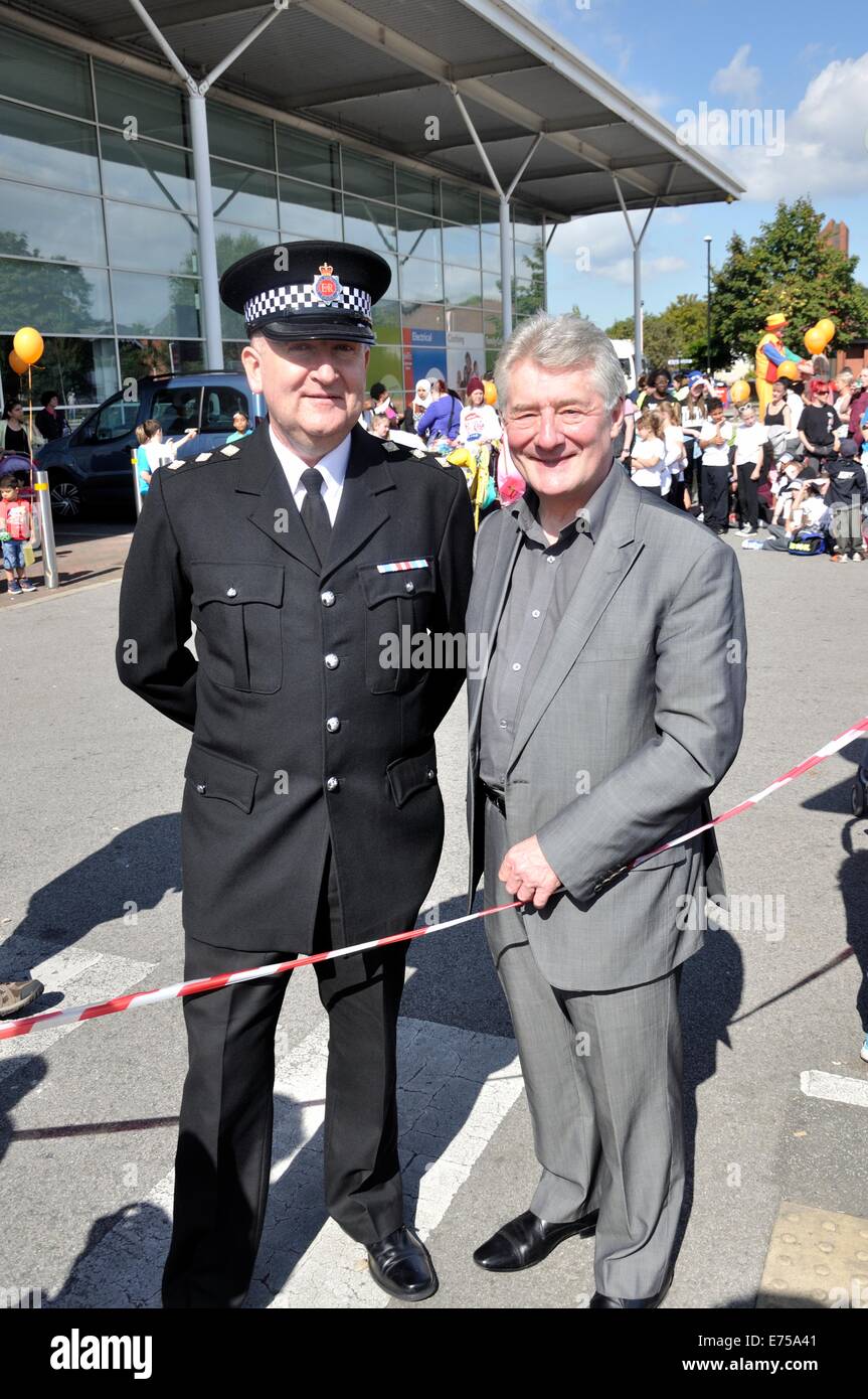 Gorton, Manchester, Regno Unito. 7 Sep, 2014. Gorton sfilata di carnevale sul modo per Debdale Park, con una sosta a Tesco car park, Gorton, per alcuni dei gruppi della Sfilata di eseguire per gli spettatori.-Ispettore Capo Patrick McKelvey, GMP con la polizia e la criminalità Il Commissario, Tony Lloyd su Tesco parcheggio auto Foto Stock