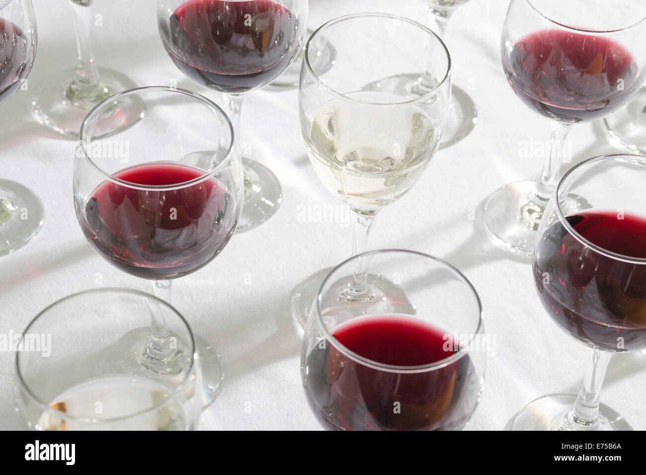 Un array di bicchieri da vino riempito con diversi tipi di vini. Foto Stock