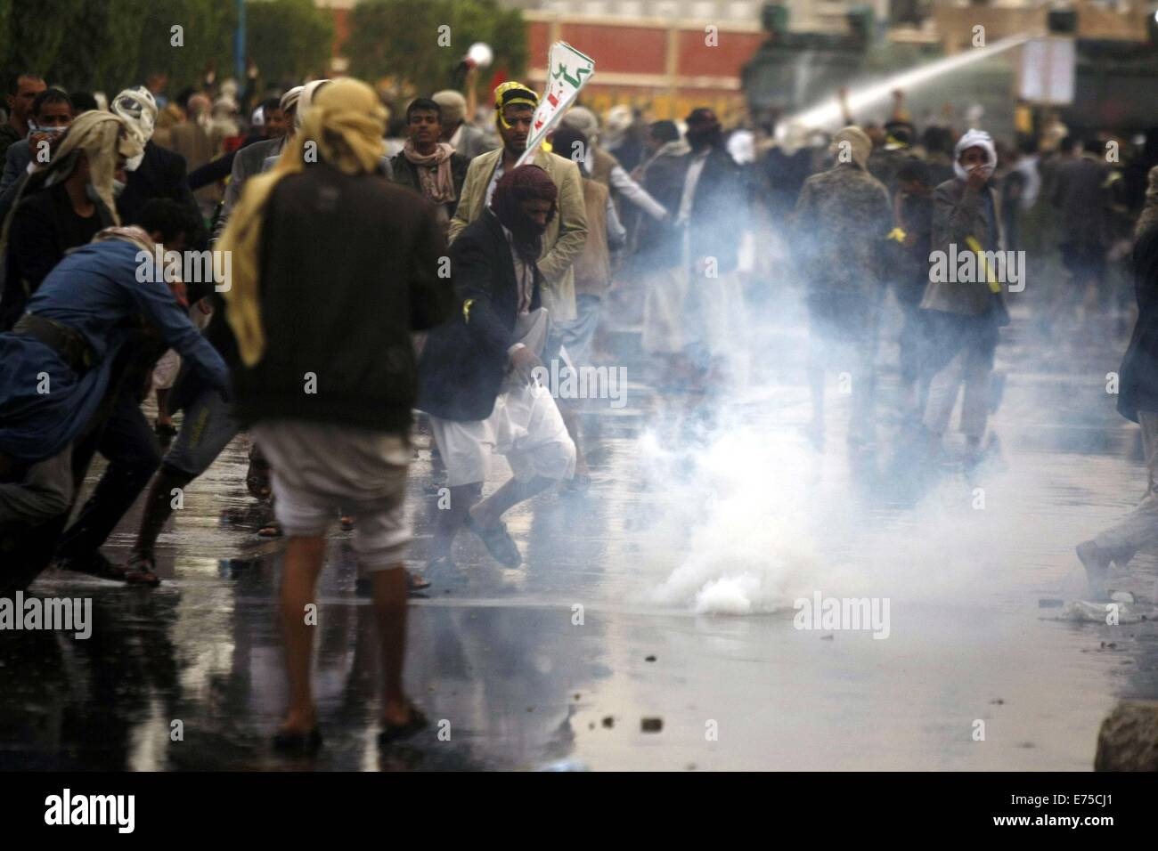 Sanaa, Yemen. 7 Sep, 2014. I manifestanti scappare dai gas lacrimogeni durante gli scontri con la polizia di Sanaa, Yemen, sul Sett. 7, 2014. Yemenita polizia antisommossa domenica sera sparato gas lacrimogeni per disperdere Houth sciita ribelli che hanno bloccato una strada principale a Sanaa Aeroporto internazionale in una escalation di loro standoff con il governo, testimoni ha detto Xinhua. Circa 10 sciita e i dimostranti sono stati feriti negli scontri. Credito: Mohammed Mohammed/Xinhua/Alamy Live News Foto Stock