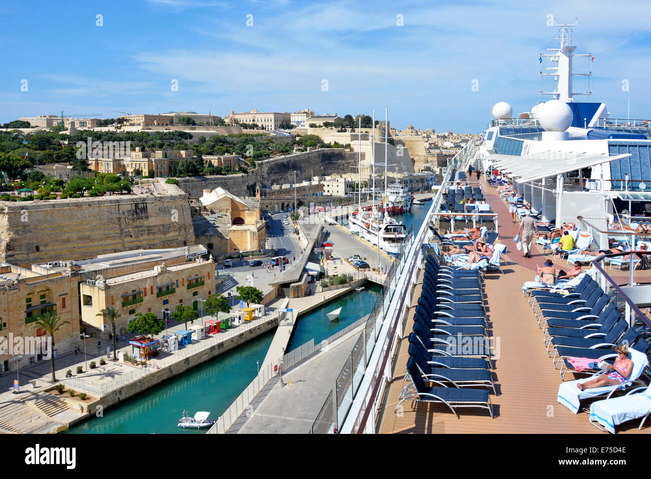 Sun deck di grandi alto e moderno di ocean nave da crociera liner & vedute della città di La Valletta & i passeggeri a prendere il sole Grand Harbour di Malta crociera Mediterraneo Europa Foto Stock