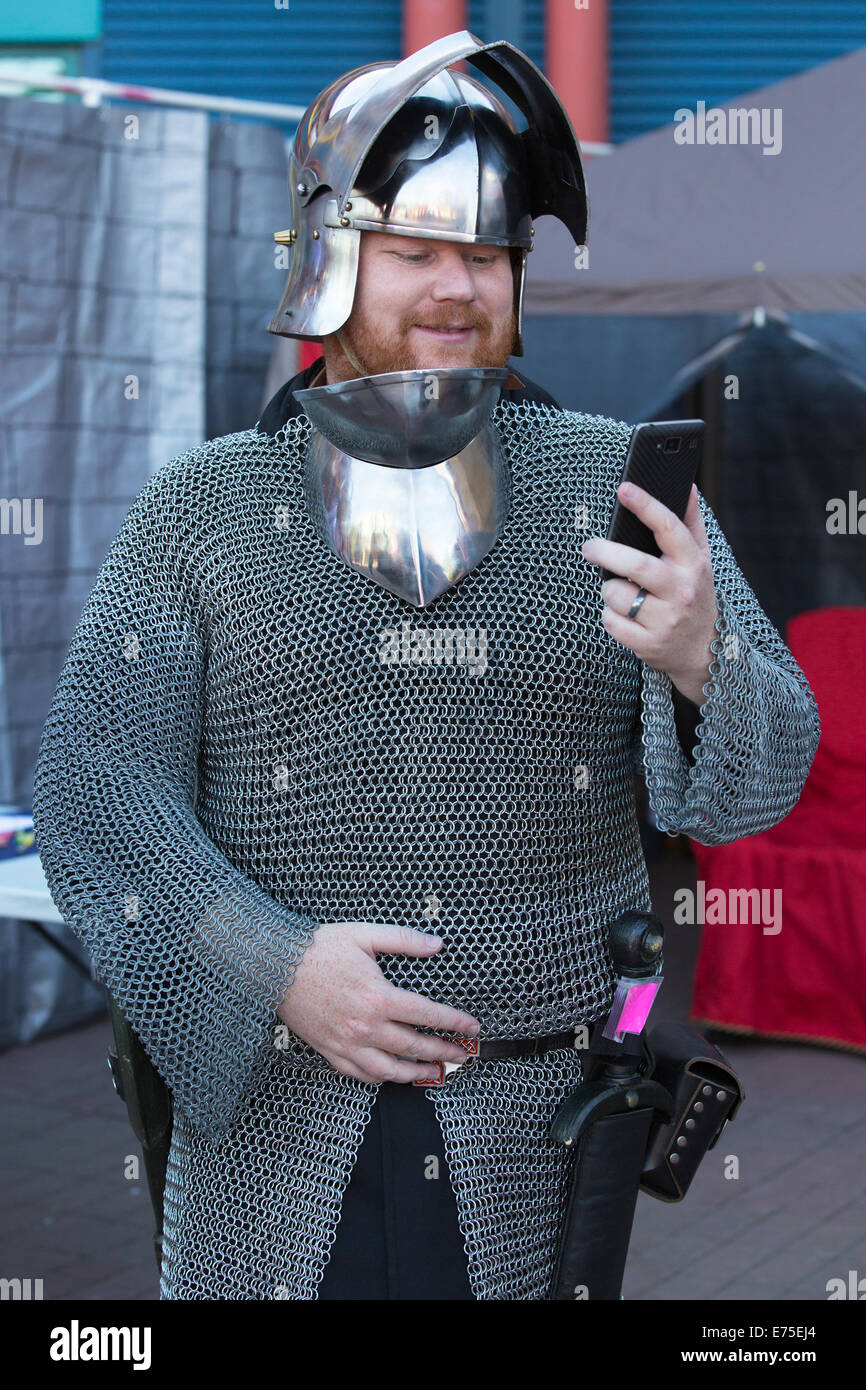 Membro del live action role-playing group Alliance Alberta vestito in costume medievale guardando smart phone Foto Stock