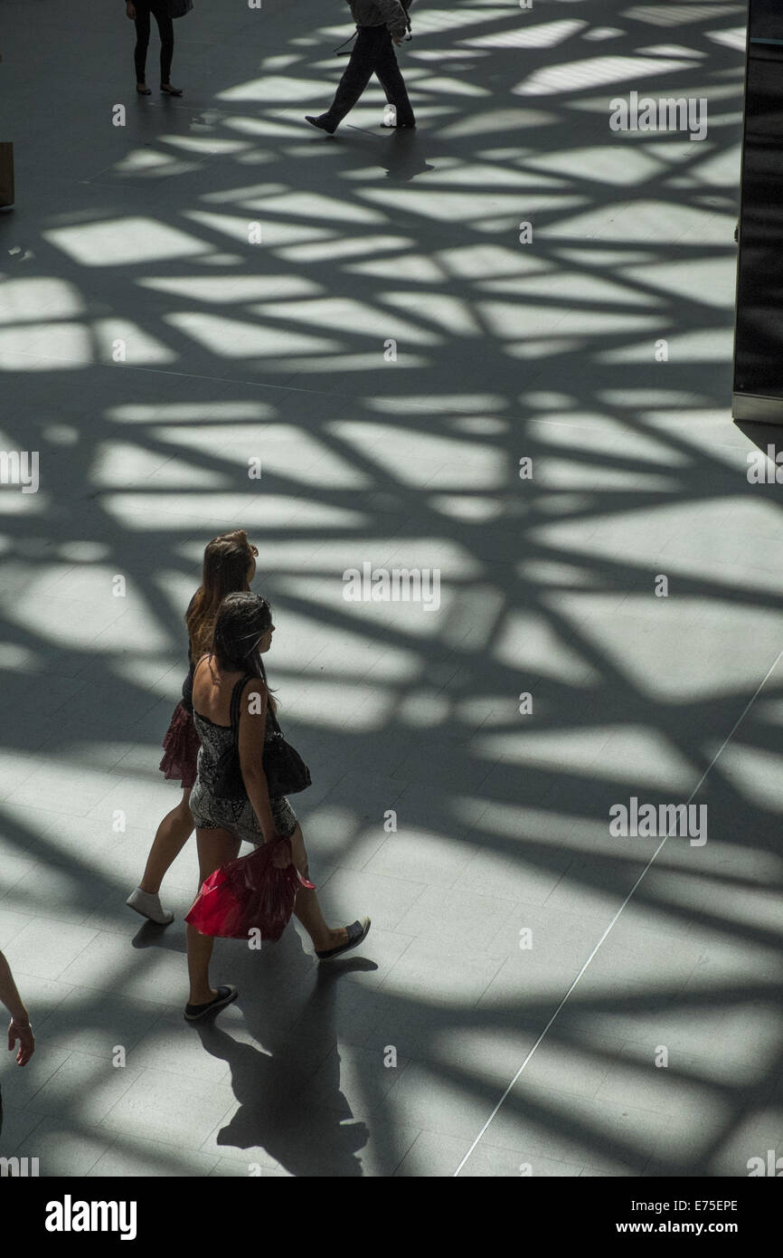 Le ombre proiettate sul pavimento sulla luminosa giornata di sole in London Kings Cross Station Foto Stock