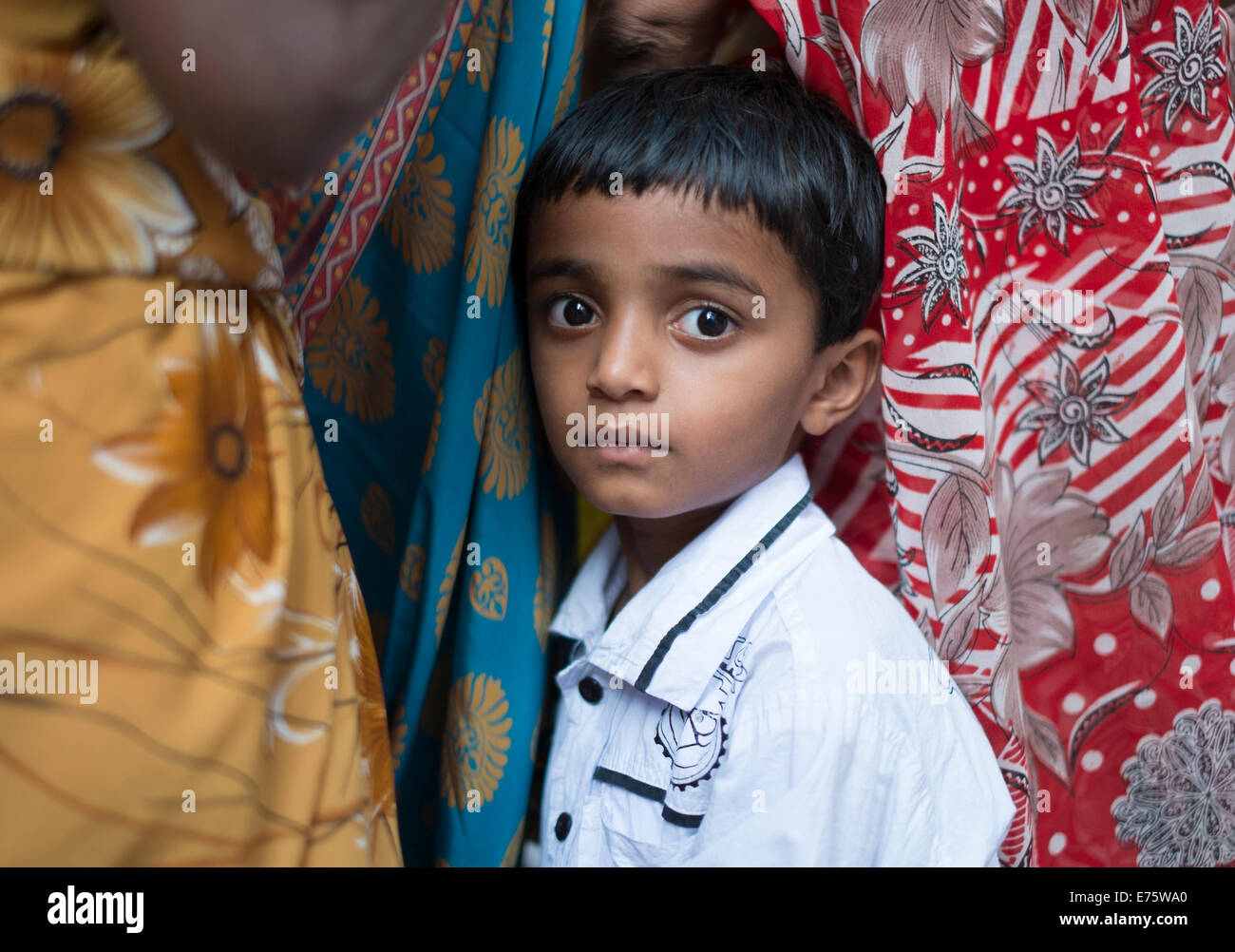 Timido ragazzo indiano nascosto tra le donne, Hyderabad, Andhra Pradesh, India Foto Stock