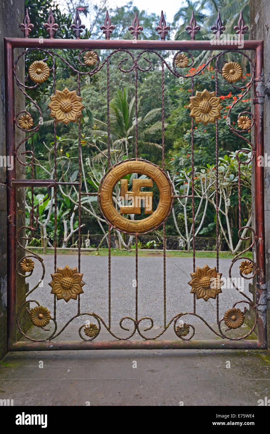 Cancello con svastica, simbolo di buona fortuna nell'Induismo, a Tirta Empul acqua tempio, Bali, Indonesia Foto Stock