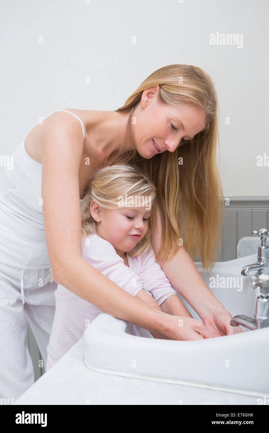 Felice madre e figlia il lavaggio mani Foto Stock