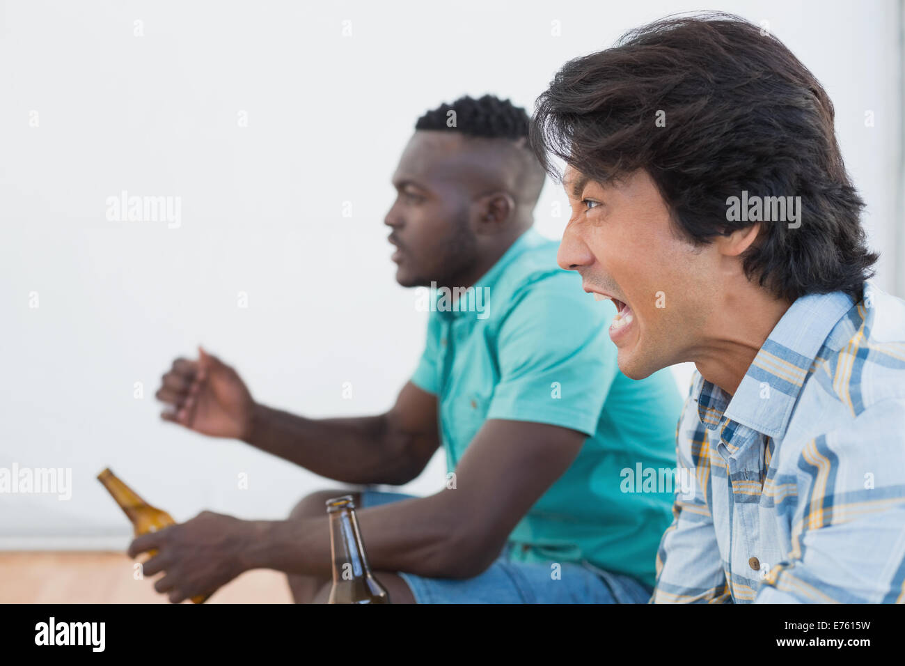 Vista laterale di due entusiasti appassionati di calcio Foto Stock