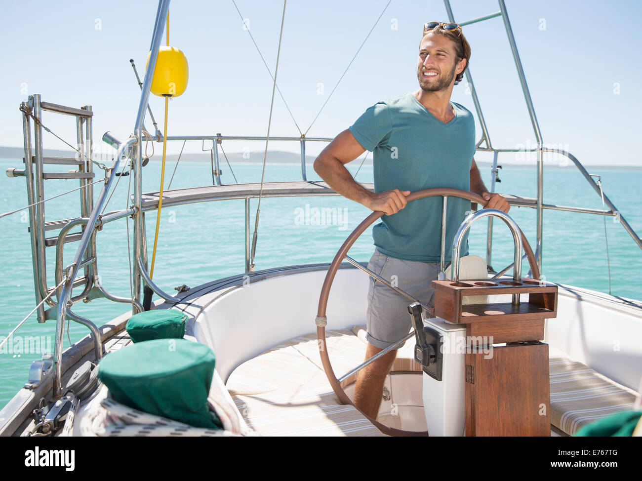 Uomo in barca a vela dello sterzo sull'acqua Foto Stock