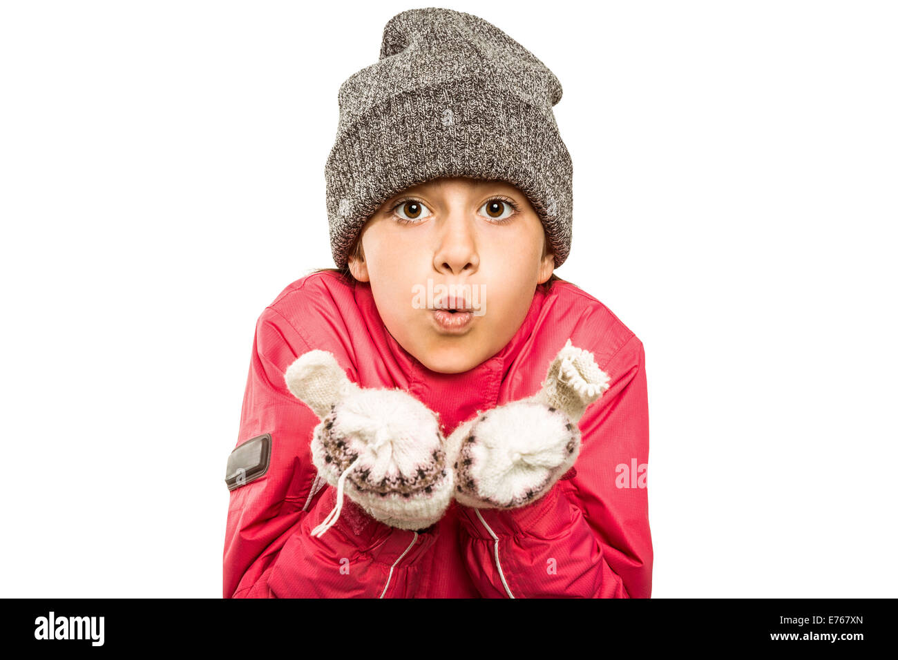 Wrapped Up bambina soffiare via le mani Foto Stock