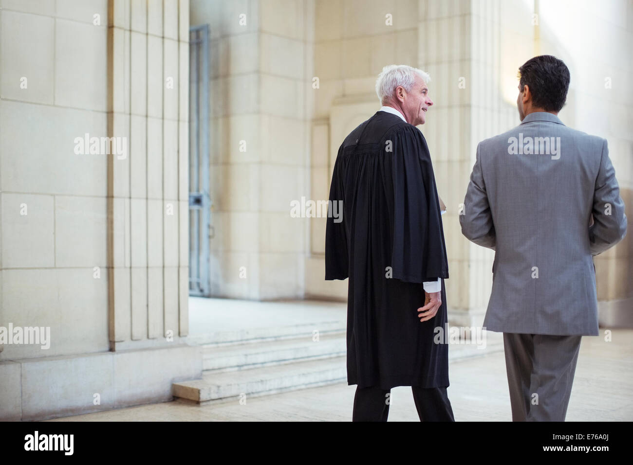 Giudice e avvocato a piedi attraverso courthouse insieme Foto Stock