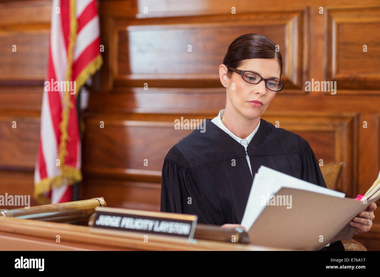 Giudice cerca attraverso documenti e banco di giudici Foto Stock