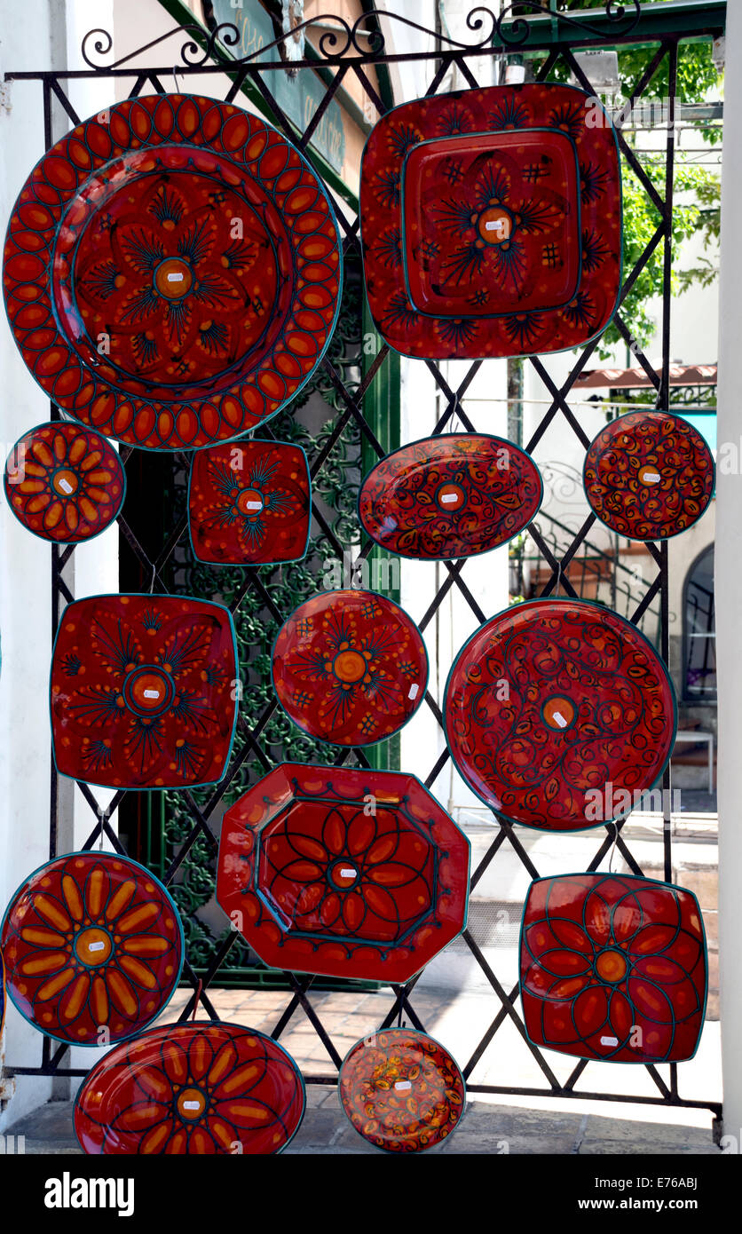 Realizzato localmente e piatti in ceramica e piastre visualizzato su una cancellata in ferro battuto in Italia. Foto Stock
