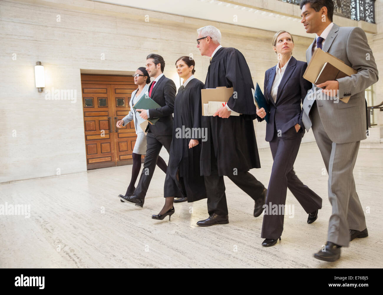 I giudici e gli avvocati a piedi attraverso courthouse insieme Foto Stock