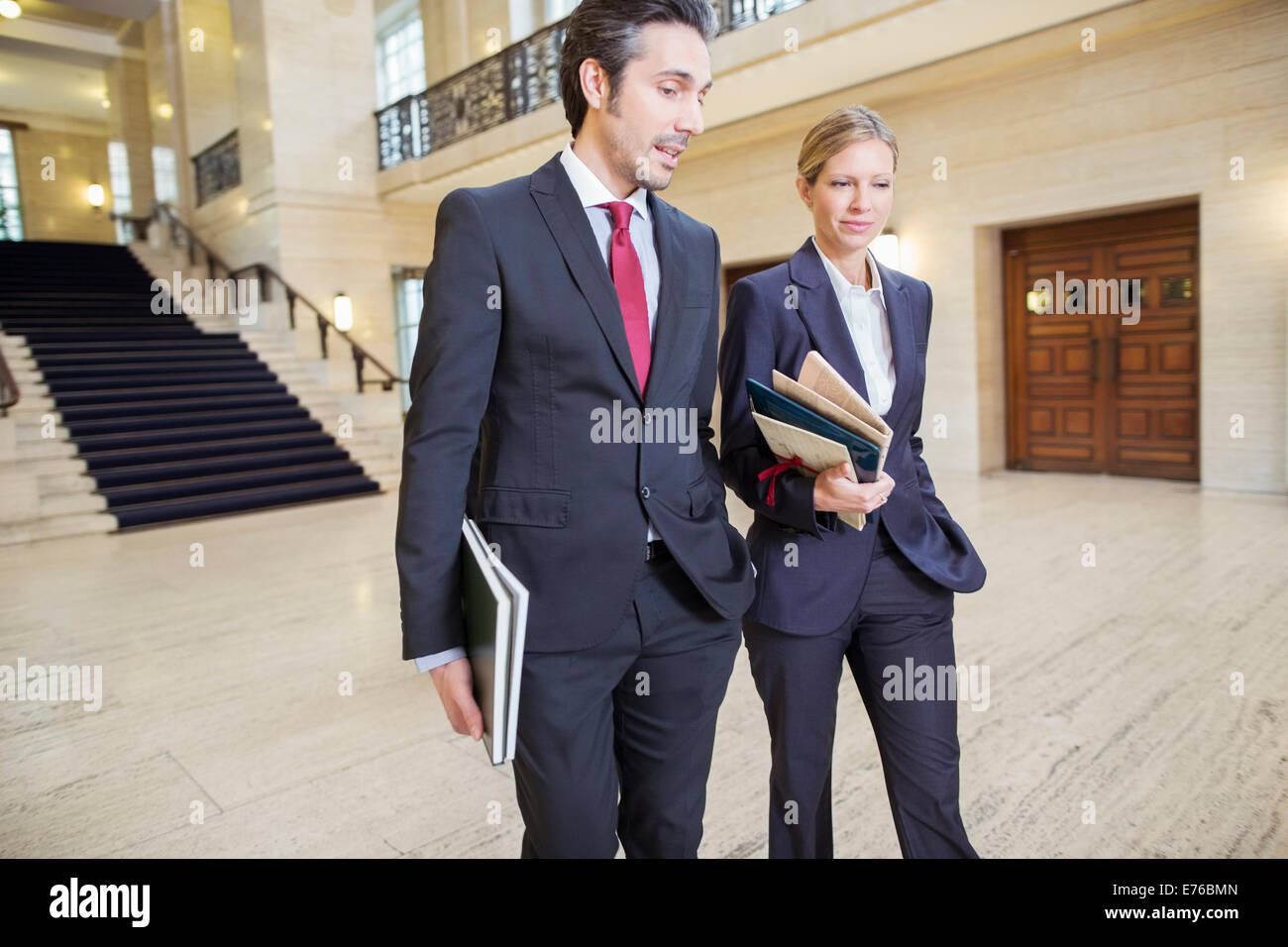 Gli avvocati a piedi attraverso courthouse insieme Foto Stock