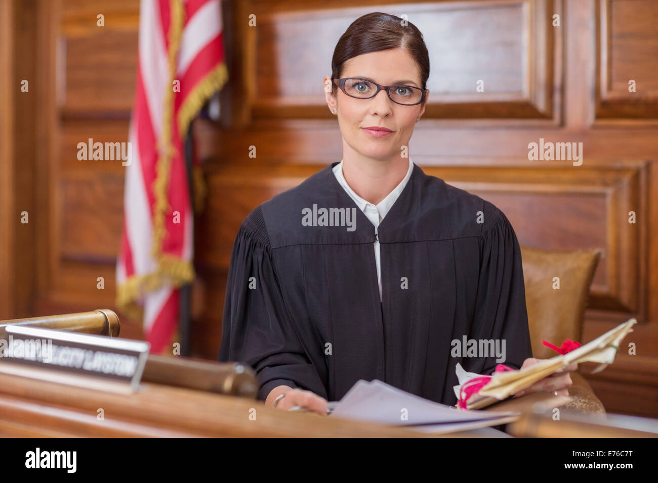 Giudice esaminando i documenti al banco dei giudici in tribunale Foto Stock