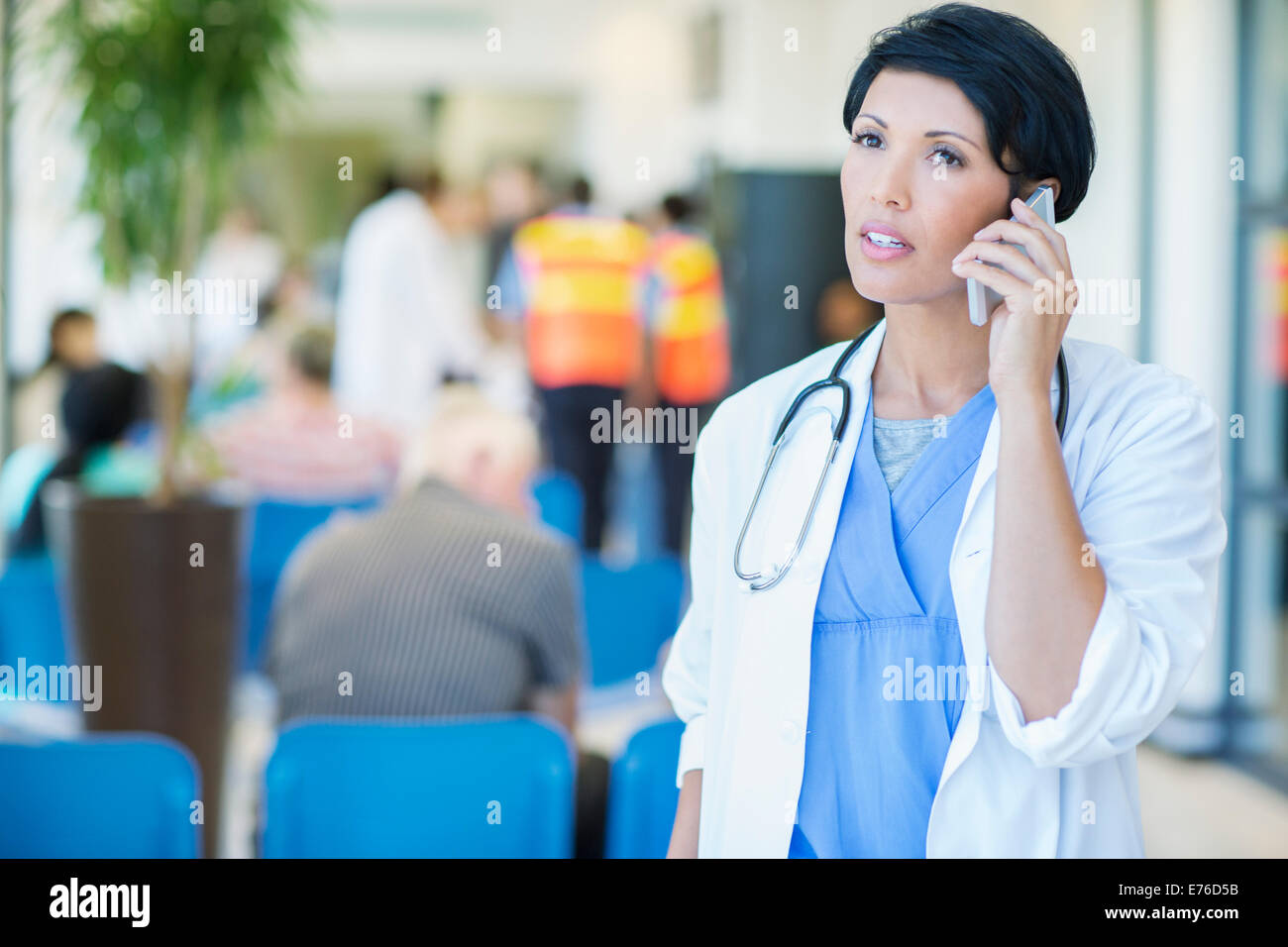 Medico parlando al cellulare in ospedale Foto Stock