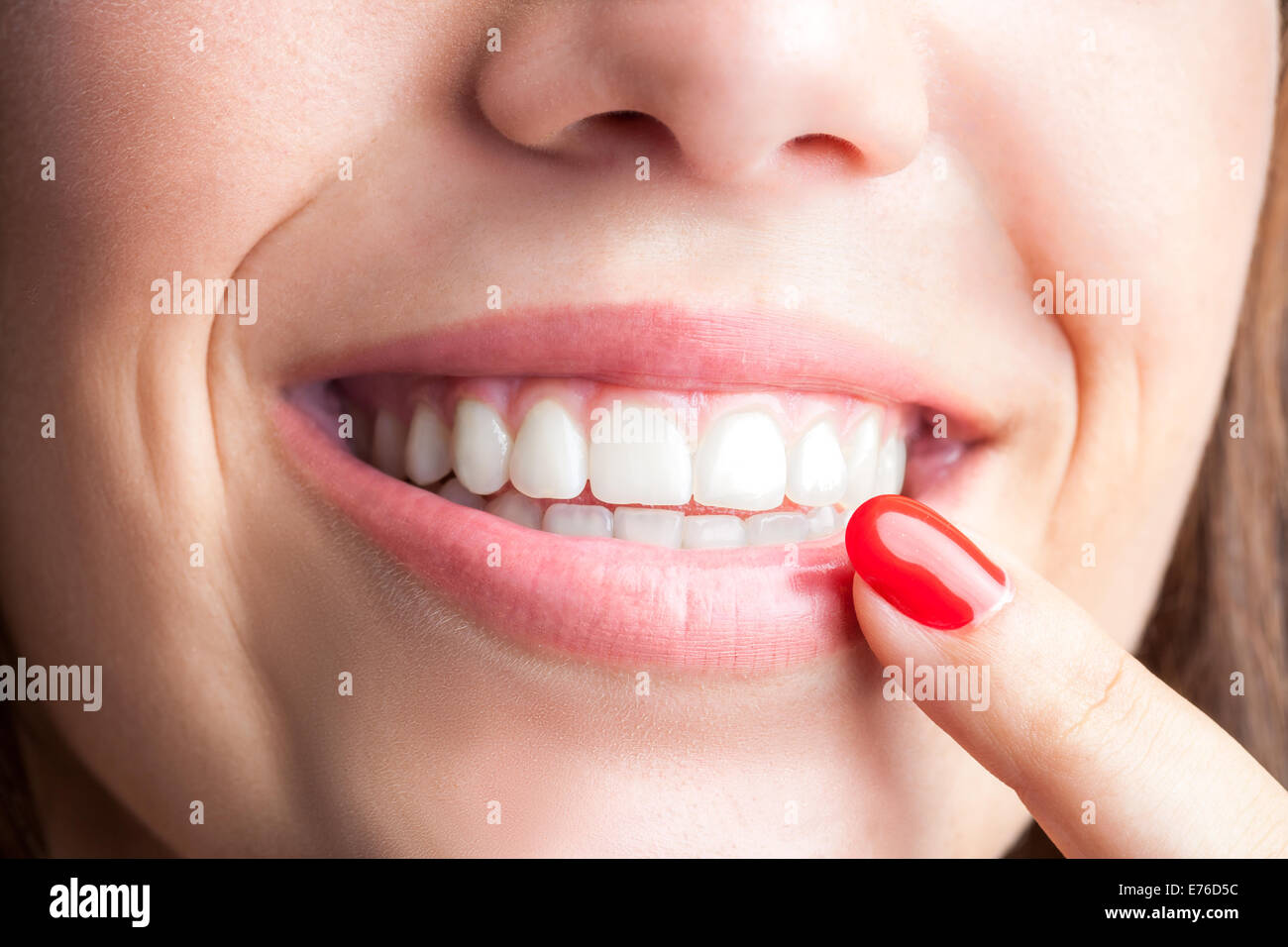 Extreme close up donna puntando con il dito in corrispondenza dei denti sani. Foto Stock