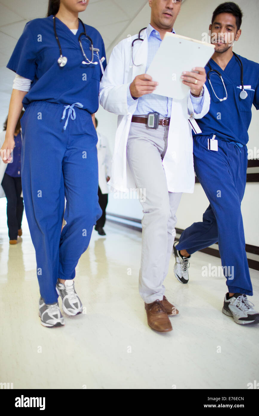 Medico e infermiere lettura grafico medico in ospedale in corridoio Foto Stock