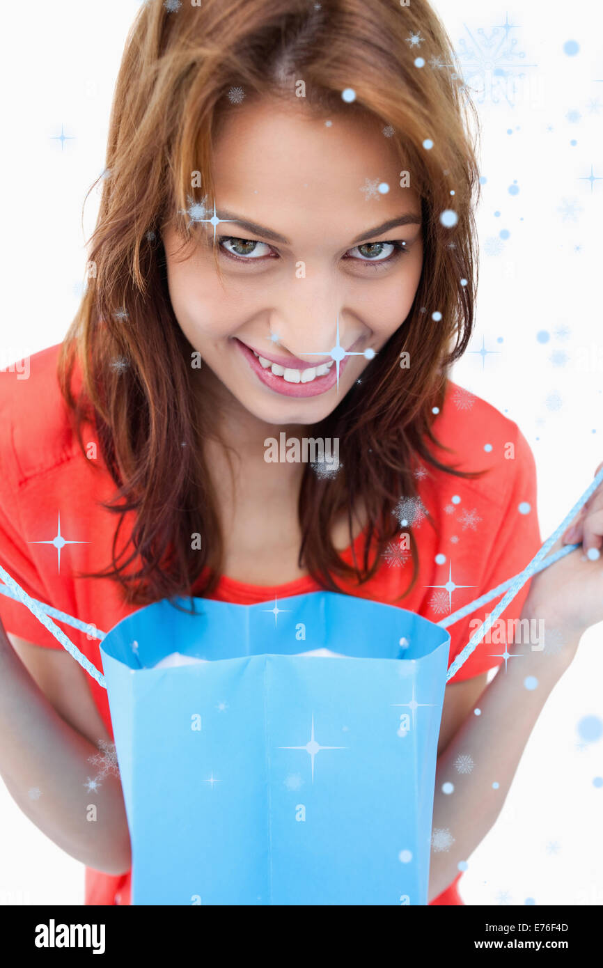 Immagine composita di adolescente sorridendo dopo guardando il suo sacchetto di acquisto Foto Stock