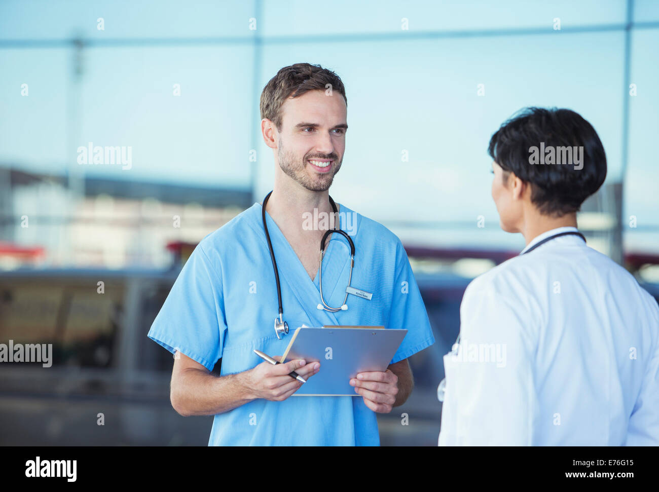 Medico e infermiere parlando al di fuori della ospedale Foto Stock