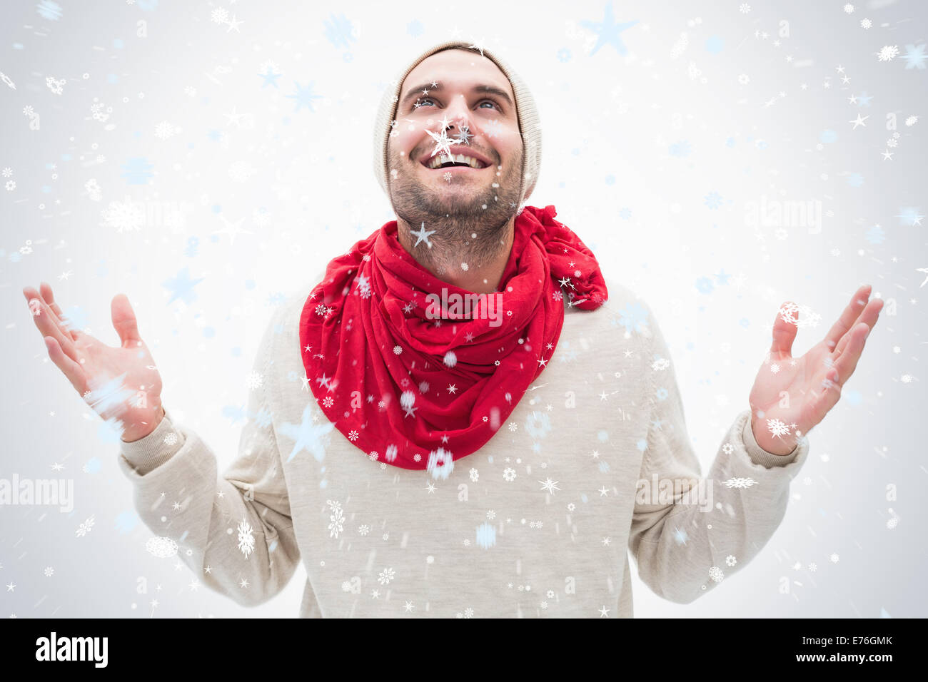 Immagine composita di attraente giovane uomo in vestiti caldi con le mani in alto Foto Stock