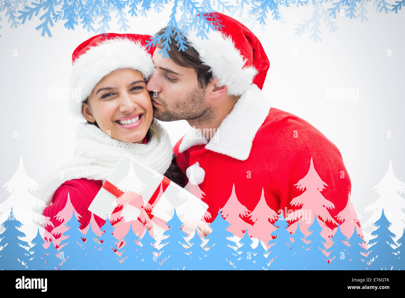 Immagine composita di attraente uomo festoso dando ragazza un bacio e presente Foto Stock