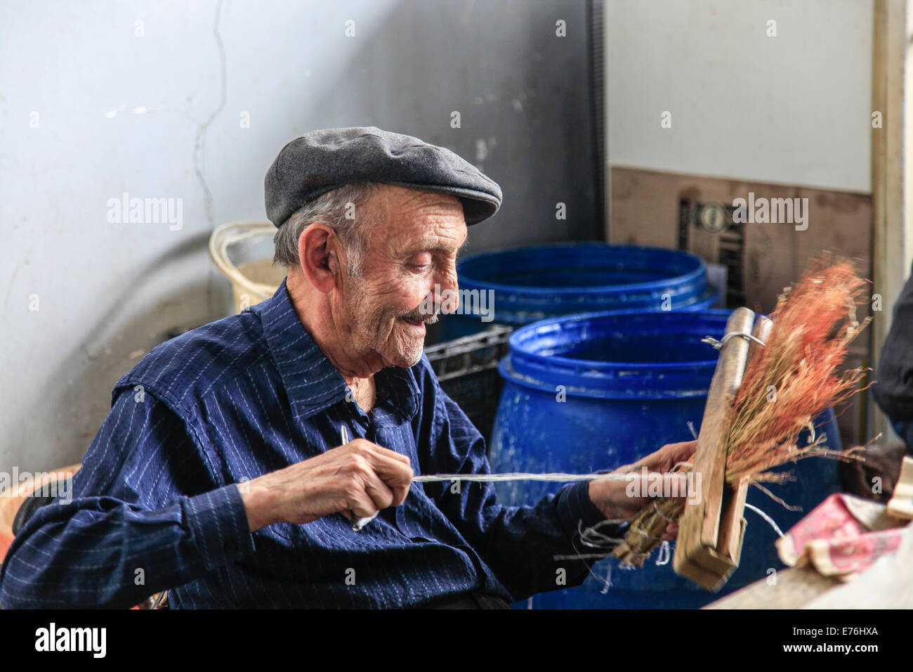 Ginestra maker cravatte legge in una scopa spazzola nel mercato, Yerevan, Armenia Foto Stock