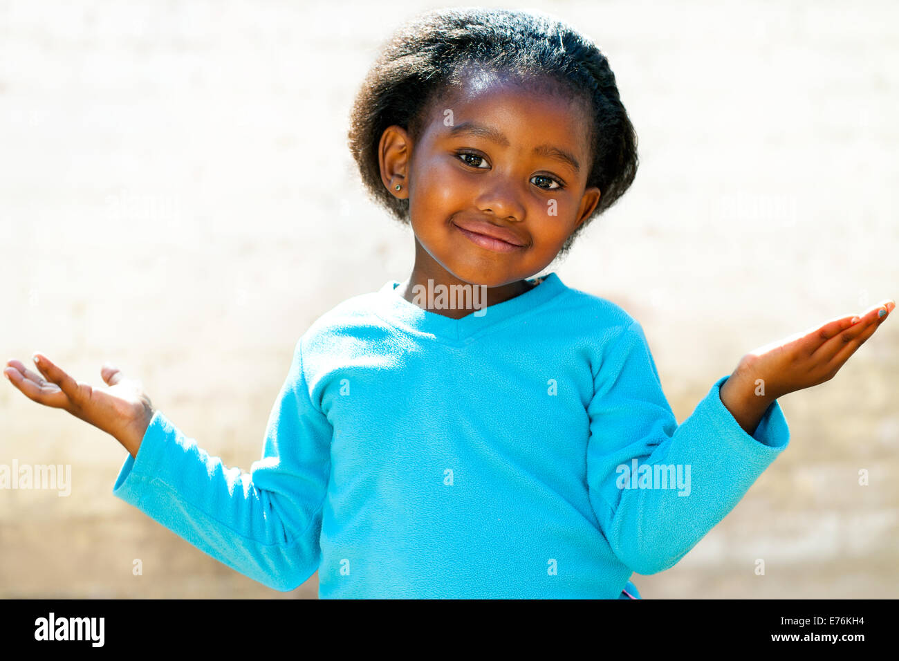 Ritratto di carino africana di capretto con i bracci aperti e chiedendo la faccia di espressione. Foto Stock