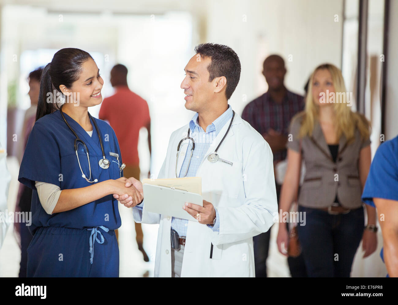 Medico e infermiere stringono le mani in ospedale in corridoio Foto Stock