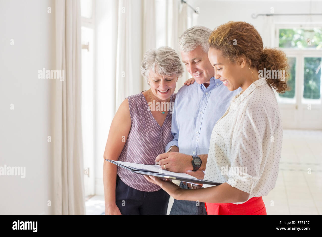 Coppia di anziani e la donna la firma dei documenti Foto Stock